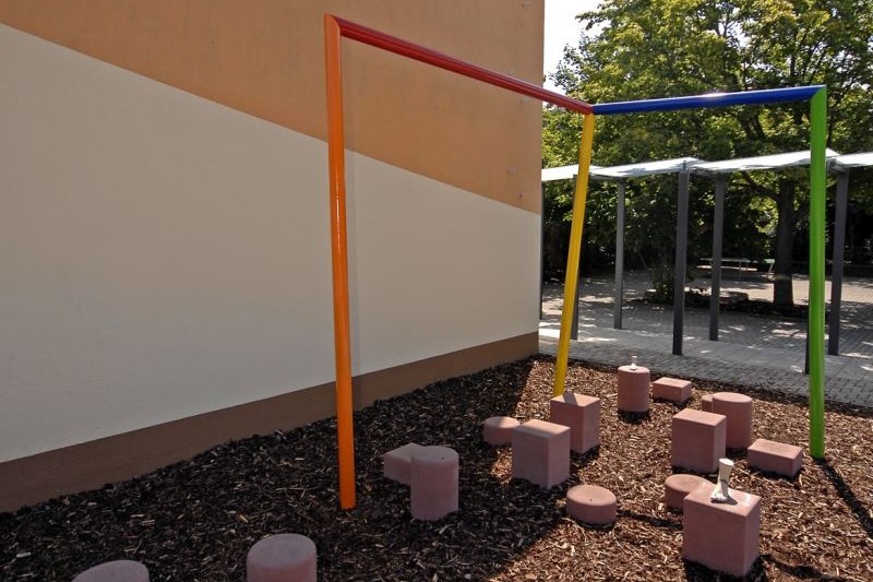  durch die farbig lackierte Stahlkonstruktion entsteht ein fiktiver Raum vor einer Wand im Außenbereich 