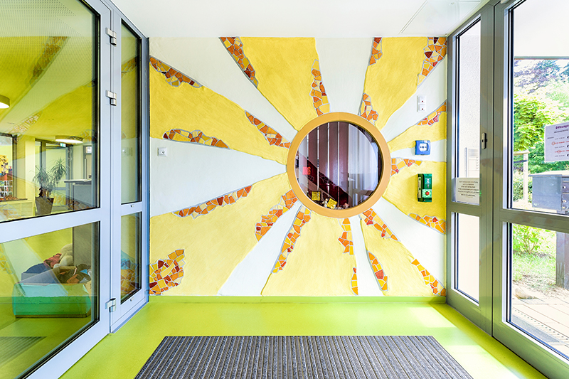 Motiv Sonne an der Wand im Eingangsbereich