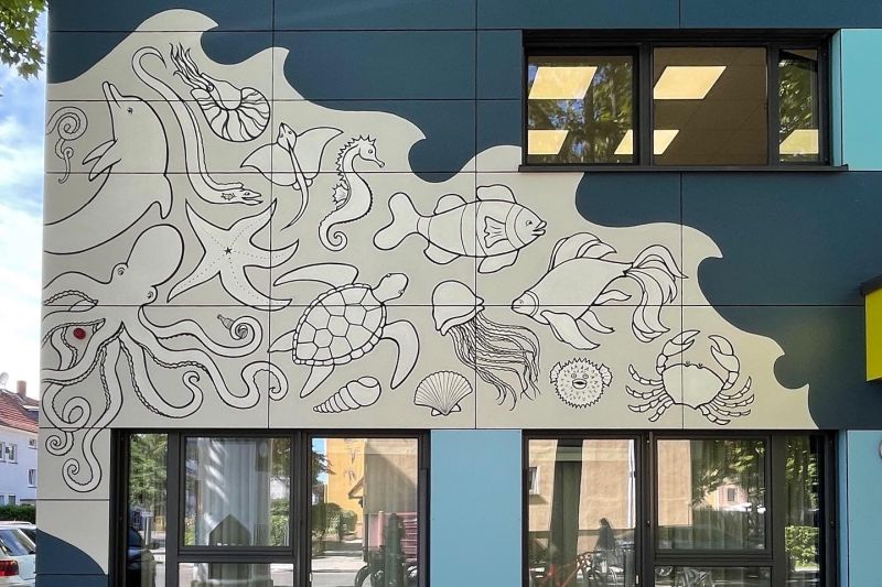 Kunstwerk in weis an der blauen Fassade 