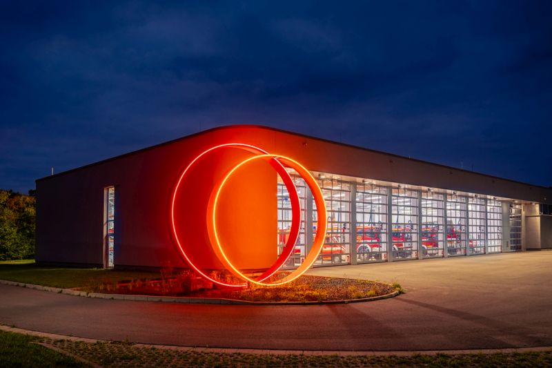 Kunstwerk leuchtet rot und gelb bei Nacht